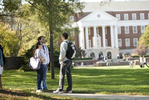 Students taslking near campus building
