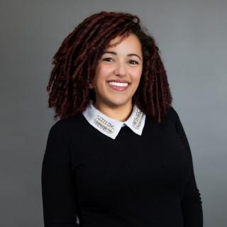 Dr. Jones, a smiling brown-skinned woman with curly hair